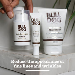 The Age Defence Skincare Routine Bundle with an antioxidant complex is displayed on a white surface. Text below reads: Reduce the appearance of fine lines and wrinkles. A hand reaches towards the products.
