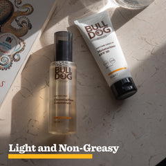 The Bulldog Skincare Anytime Daily Moisturiser SPF 30, which offers UVA/UVB protection, is placed on a marble surface in sunlight. Light and Non-Greasy appears at the bottom.