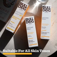 Three Bulldog Skincare products on a light surface: Anytime Daily UV Moisturiser SPF 50 for sweat-resistant protection, Moisturising Gel Cream, and Cleansing Face Concentrate. Sunlight casts shadows. Text reads: Suitable for all skin tones & all-day hydration.